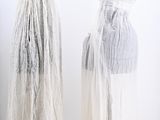 two mannequins dressed in white dresses on display in a white room