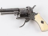 a close up of a revolver with a wooden handle on a white surface