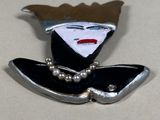 a picture of a pin with a woman ' s face on it