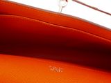 an orange purse with a metal handle on a white background