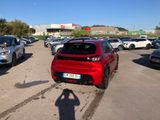 a red car parked in a parking lot with other cars