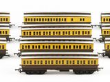 several yellow and black train cars are lined up on a white surface