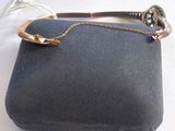 une image représentant un sac à main noir entouré d'une chaîne dorée