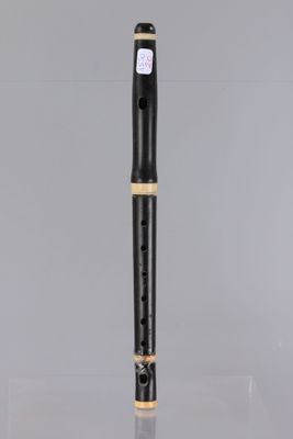 a flute with a black body and gold trim on a clear surface