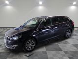 Une voiture noire est garée dans une grande pièce au sol carrelé.