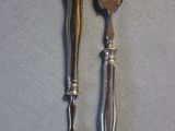 two forks and a spoon sitting on a table