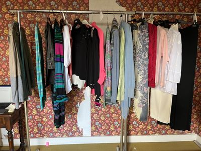 a rack of clothes hanging on a clothes rack in a room