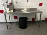une table en métal sur laquelle se trouve une poubelle