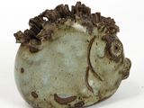 a small ceramic fish shaped object on a white surface