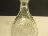 a clear glass bottle with a stopper on a table