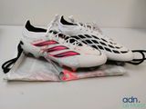 adidas soccer cleats on top of a bag on a table