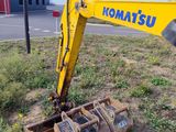 a yellow excavator that is sitting in the grass