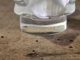 a glass of water sitting on a table with a bird figurine in it