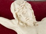 a white statue of jesus on a red cloth