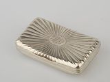 un étui à cigarettes ancien en argent, orné d'un motif en rayons de soleil sur le devant