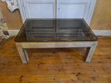 une table en verre avec un plateau en verre posée sur un parquet