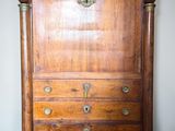 a wooden chest of drawers with brass hardware on it