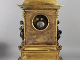 a gold clock with a bird on top of it