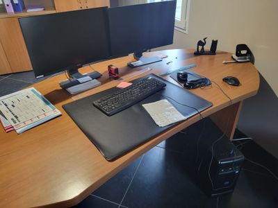 a computer desk with two monitors and a keyboard on it