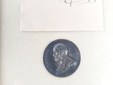 a silver coin with a drawing of a man on it