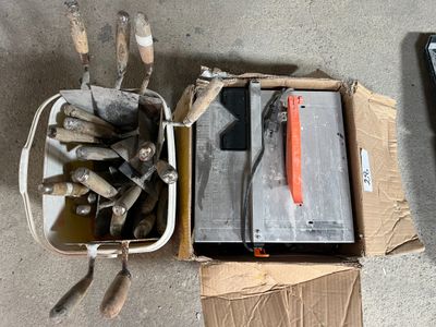 une boîte à outils posée par terre à côté d'une boîte de marteaux