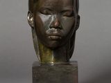 sculpture en bronze représentant la tête d'une femme aux yeux fermés