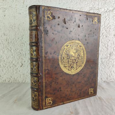 an old book sitting on top of a table next to a white wall