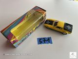 une petite voiture jaune à côté d'une boîte de bonbons