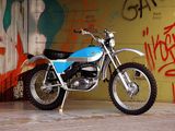 a motorcycle parked in front of a wall with graffiti on it