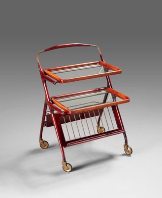 a red metal and glass trolley with a magazine rack on wheels