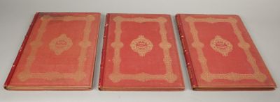 three red books sitting on top of a table next to each other