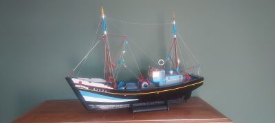 une petite maquette de bateau posée sur une table en bois