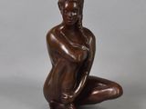 bronze statue of a woman kneeling on her knees with her hands on her knees
