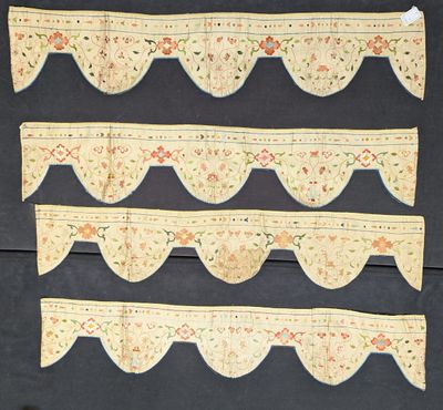 three pieces of cloth with scallops on them are hanging on a wall