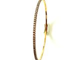 gros plan d'un bracelet en or avec des diamants sur fond blanc