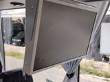 a man sitting in a bus with a monitor on his head