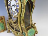 a green and gold clock sitting next to a picture frame