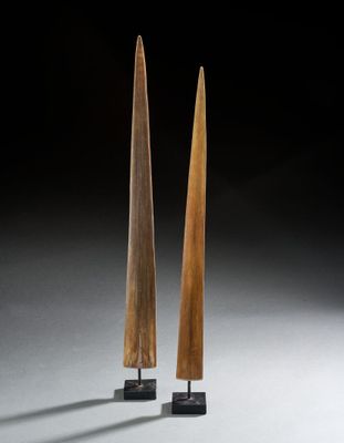 une paire de sculptures en bois posées sur des socles, sur fond noir
