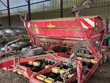 le tracteur est garé sur le terre battu, à côté de la remorque