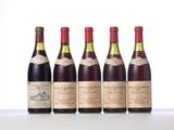four bottles of wine are lined up on a table