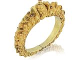 gros plan d'une bague en or sur fond blanc