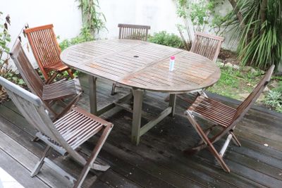 a wooden table and four chairs on a deck