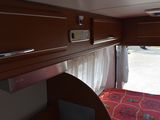 a view of the inside of a camper with a bed and a desk