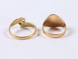 two gold rings with a green stone in the middle of them