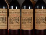 three bottles of red wine are lined up on a table