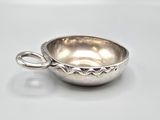 silver plated bowl with handle on white surface