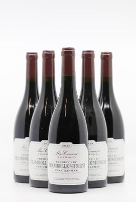 quatre bouteilles de vin sont alignées sur une surface blanche