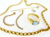 a necklace, ring, pin, and other jewelry on a white surface