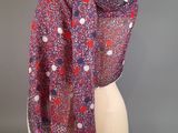 a red and white scarf with polka dots on it on a mannequin