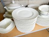 many plates and bowls on a shelf in a room
